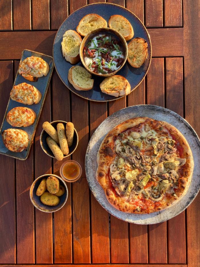 Zonnig terras met pizza en voorgerechten